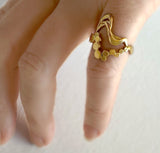 Wavy ring i guld - Unikt smykkedesign med snoet organiske bølger og flade bobler, vist på finger - Livva