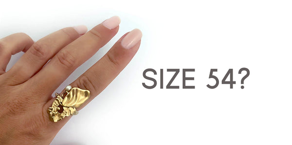 Hand with big organic gold ring on the index finger - Guide on how to check ring size at home.