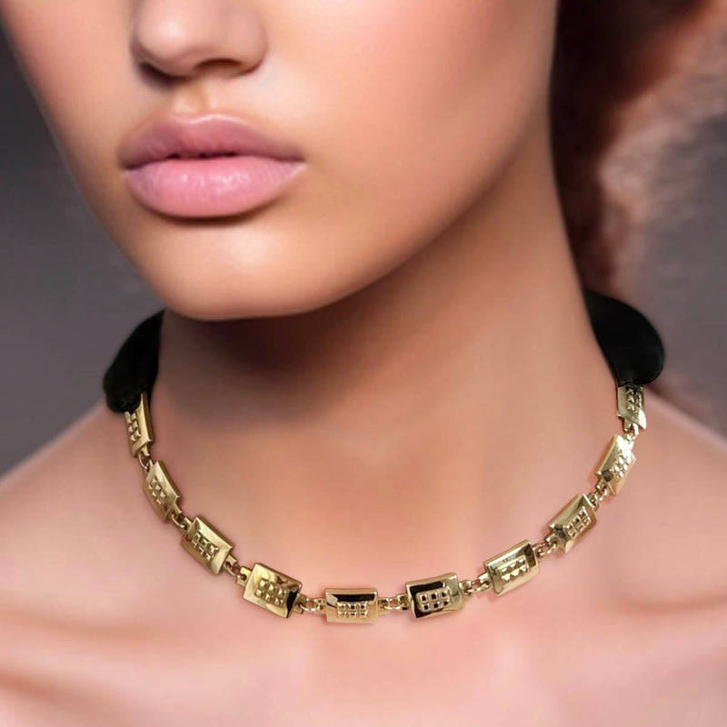 Black satin ribbon on chunky square necklace in gold on model - Livva Østerby.