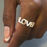 Love Love Love - Bogstav-ring i sølv med 3 sammensatte ord som ringbånd og kærligheds-symbol, vist som closeup på finger - Livva