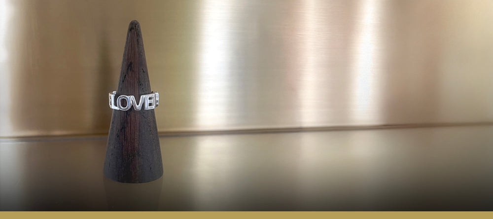 Love Love Love - Ord-ring i sølv med 3 sammensatte ord som ringbånd og kærligheds-symbol, vist på display - Livva