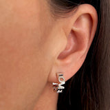 Bgstav ørering hvor ordene LOVE LOVE er sammensat som udskårne bogstaver i sterling sølv, vist på øre - Livva