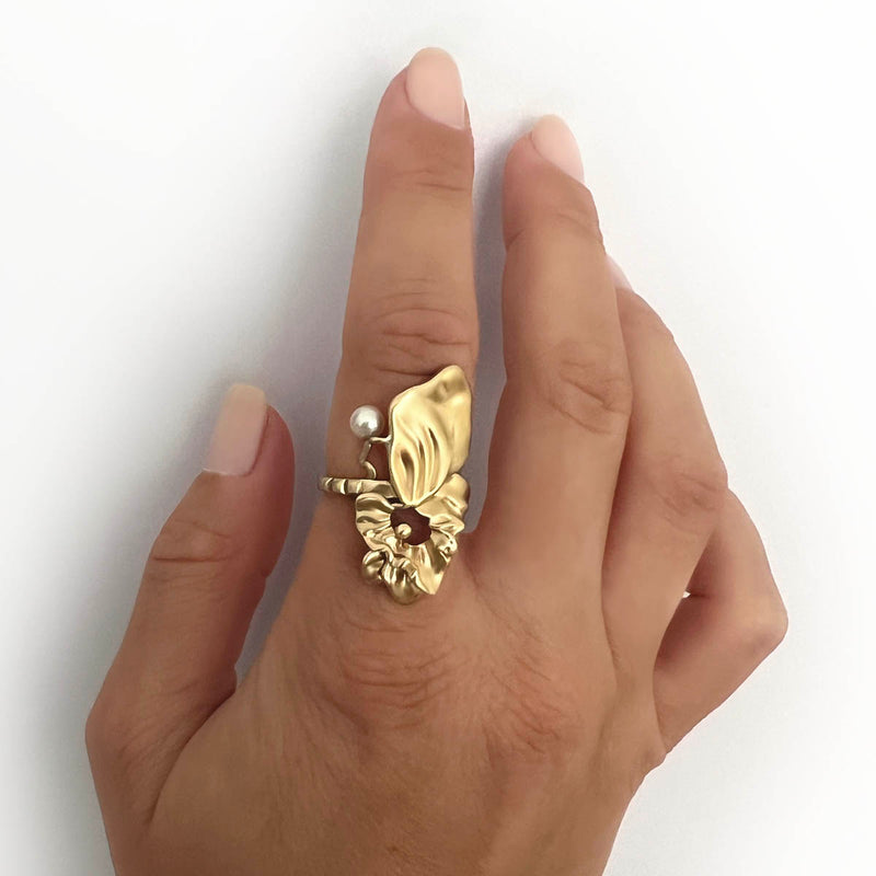 Organic gold ring with a floating white pearl – A surreal statement ring covering a model’s finger - Alva Florali 