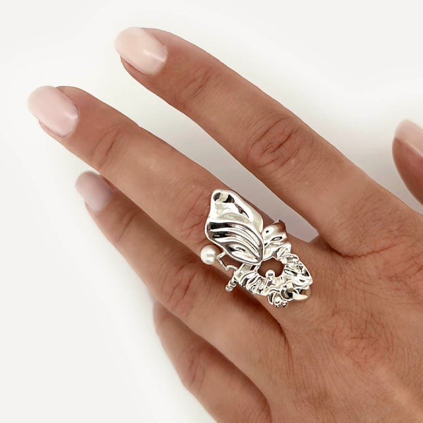 Organisk ring i sterling-sølv med flyvende hvid perle - Surrealistisk ring, der dækker en models finger - Livva