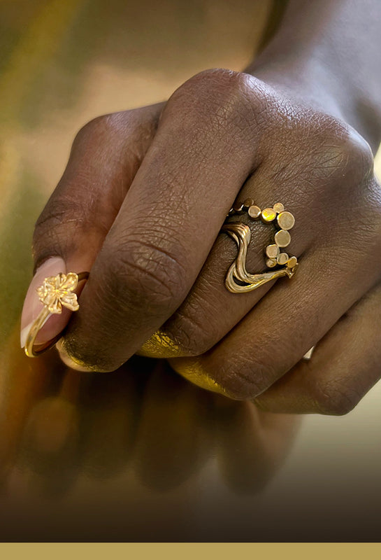 Organisk Wavy ring og en lille blomster ring i guld på hånd - Livva