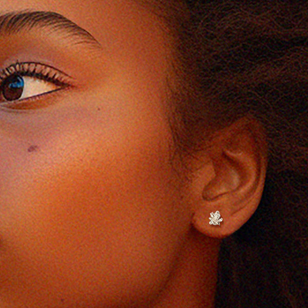 Små blomster øreringe - Delikat ørestik i organisk design af blade i sølv, vist på øre – Livva