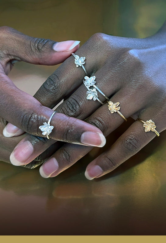 Et hav af små blomster ringe i guld og sølv vist på hænder - Livva