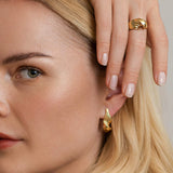 Snoede øreringe og ring - Luksuriøst organisk dansk design i et skulpturelt twist i 18k guld med rillede linjer, vist på model - Livva