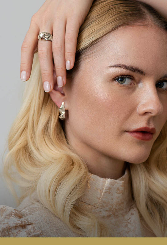 Snoet sølvring og ørering - Luksuriøst organisk dansk design i et skulpturelt twist med rillede linjer, vist på model – Livva