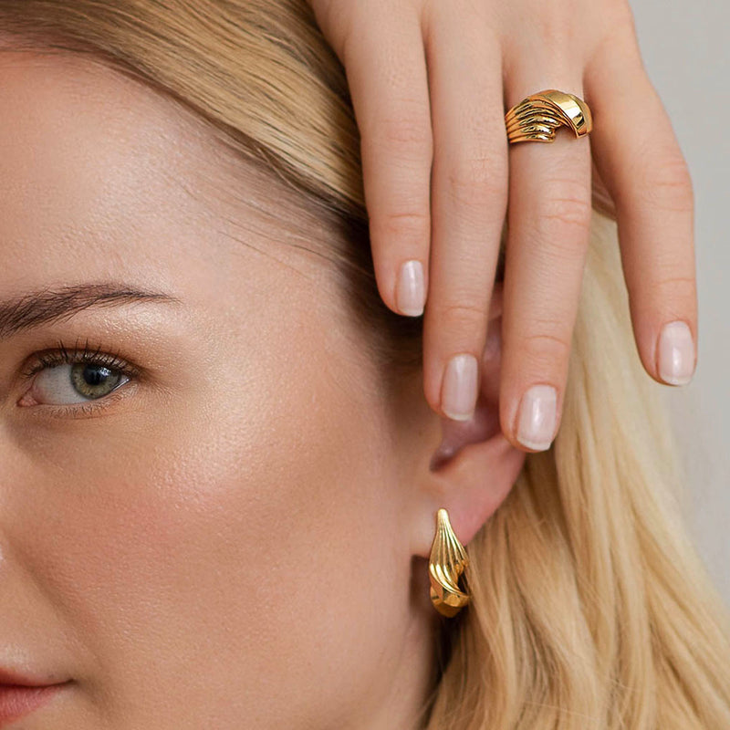 Snoet ring og ørering i guld - Et dansk organisk smykkedesign i særklasse med riller i 18k massivt guld, vist på model - Livva
