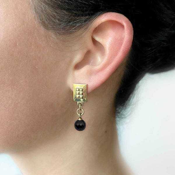 Square earrings gold – A square design with tiny studs and an elegant black spinel gemstone dangle on model – Livva Østerby.