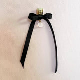 Square earrings – Square gold design with tiny studs & elegant snow quartz gemstone dangle with black satin bow – Livva Østerby.