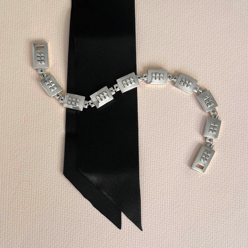 Square link chain necklace – Shows the black satin ribbon separate and interchangeable from the silver chain - Livva Østerby.