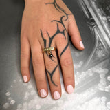 Square ring gold – A sleek design with tiny studs & black spinel dangle charm on hand with posh punk tattoo – Livva Østerby.