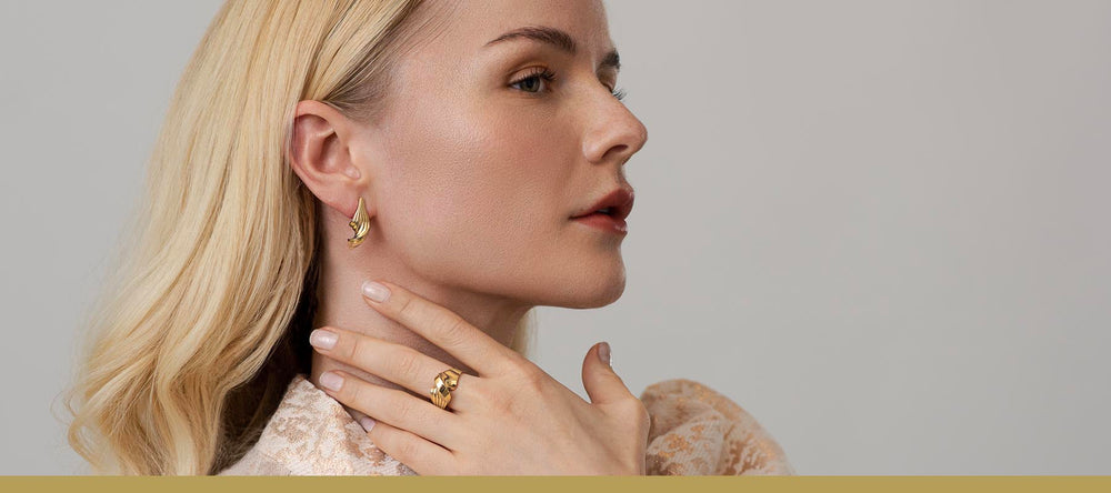 Grace York collection twisted ring and earrings in yellow gold on model by Livva Østerby.