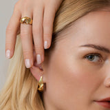 Twisted ring gold and earrings – A luxurious organic Danish design in sculptural twist of grooved lines in gold, on model – Livva