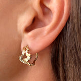 Wavy øreringe i guld - Unikt smykkedesign med snoet organiske bølger og flade bobler, zoomet ind på øre - Livva