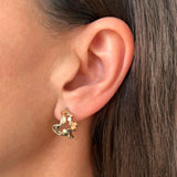 Wavy øreringe i guld - Unikt smykkedesign med snoet organiske bølger og flade bobler, vist på øre - Livva