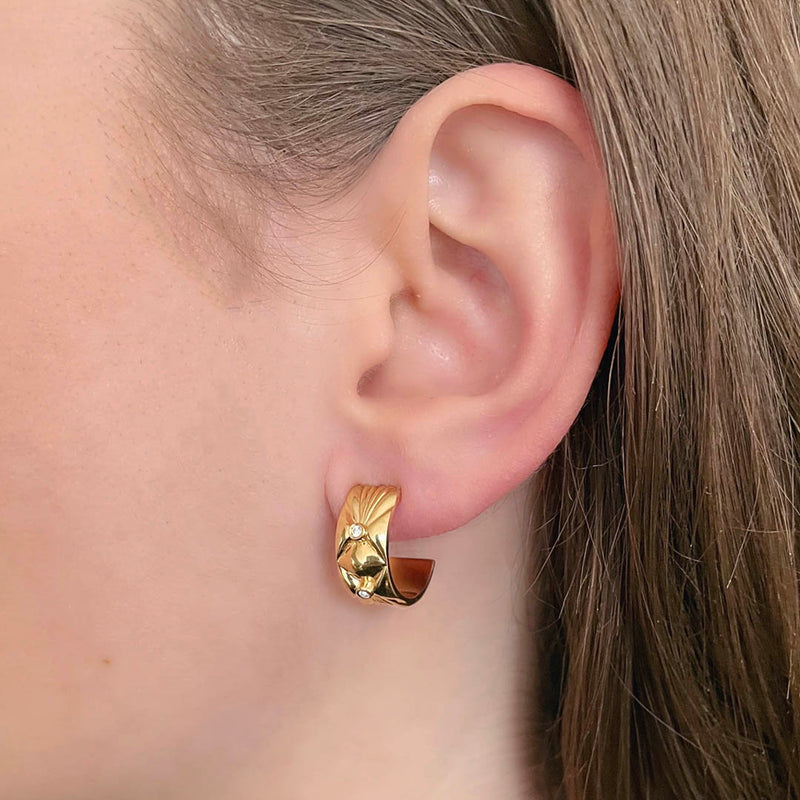Wide gold earrings - A sculptural Danish design with quilted organic top in 18k solid gold and white diamonds, on model - Livva