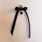 Firkantede øreringe i guld med små nitter og dinglende facetslebet ædelsten af sort spinel, samt en sort satin sløjfe - Livva