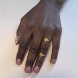 To små blomster ringe på samme finger – Organisk smykke i guld med små naturlige blade sat på tynd ringskinne - Livva
