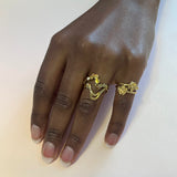 To små blomster ringe på samme finger – Organisk smykke i guld med små naturlige blade sat på tynd ringskinne, vist sammen med Wavy ring - Livva