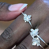 Tre små blomster ringe i sølv – Organisk smykke med små naturlige blade på tynd ringskinne, vist på fingre - Livva