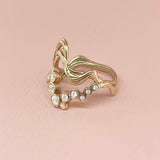 Wavy ring  i 18k guld - Et unikt dansk smykkedesign af snoet organiske bølger sammen med 14 hvide diamanter i legende bobler, set fra siden - Livva